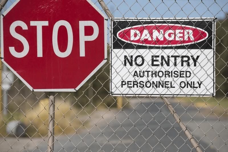 A Stop Sign and A Danger Sign on A Chain Link Fence — Imsprint in East Maitland, NSW