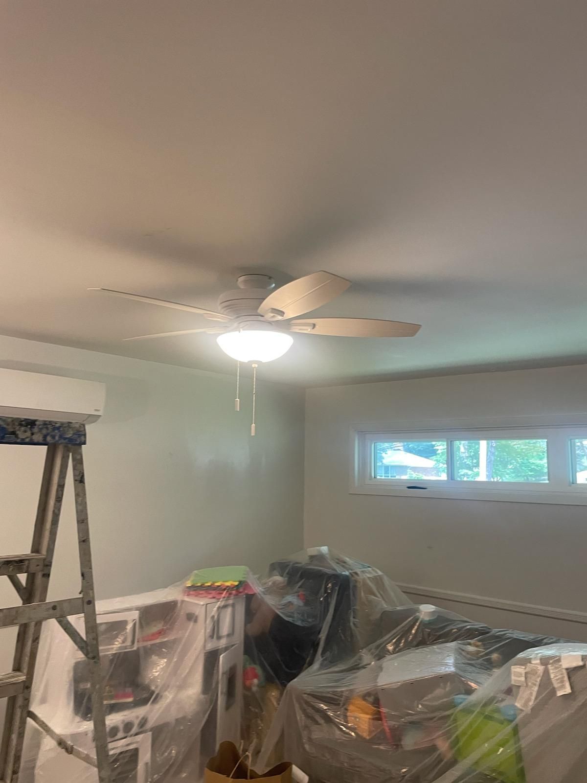 A ceiling fan is hanging from the ceiling of a room.