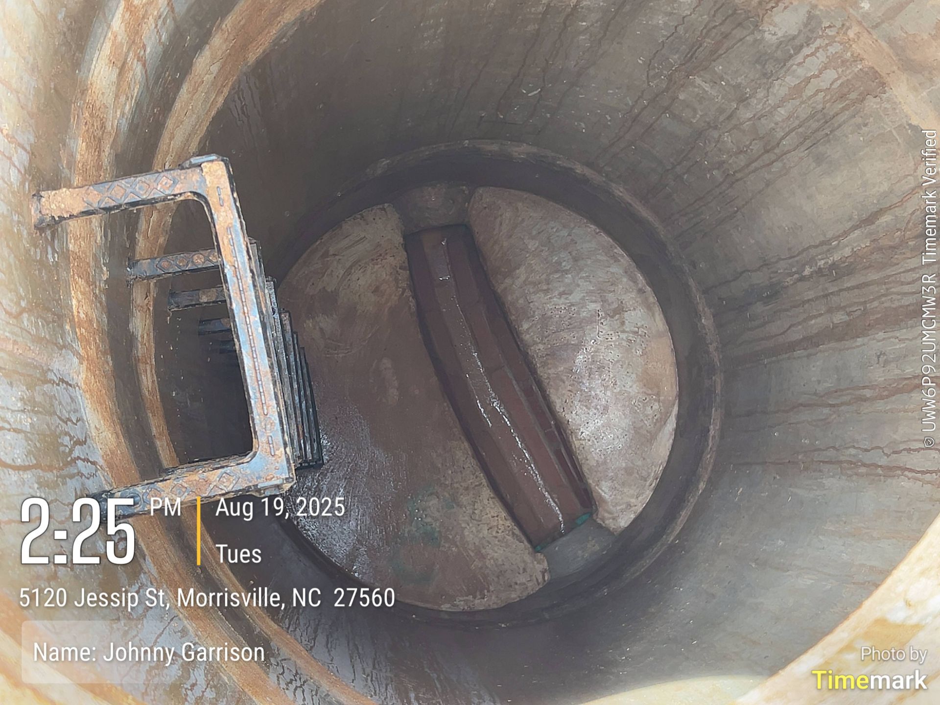 View inside a cylindrical structure with a rusty metal object and valve.