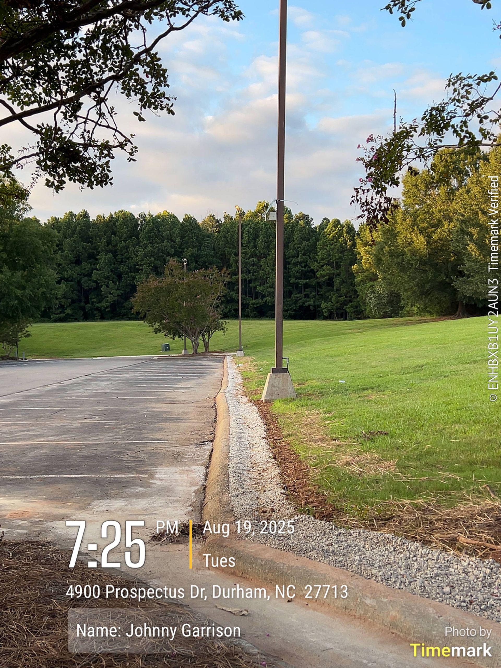 Parking lot and grassy area with trees, two tall poles. The location is in Durham, NC.