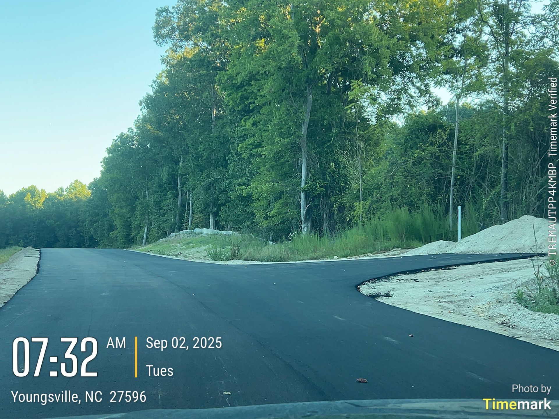 Paved road curves into wooded area. Time/date stamp shows 07:32 AM, Sep 02, 2025, Youngsville, NC.