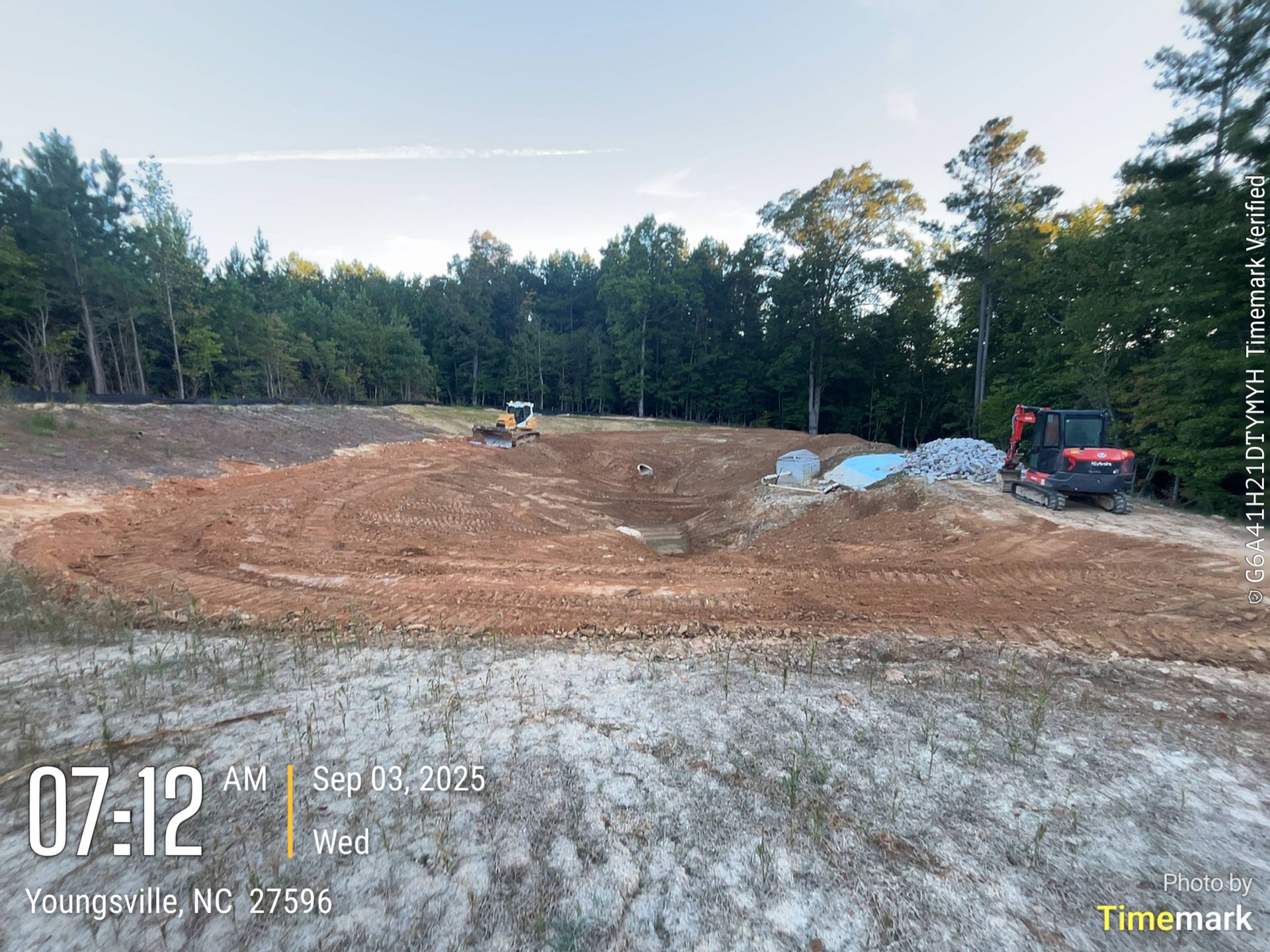 Construction site in Youngsville, NC at 7:12 AM on September 13, 2023, with heavy machinery and cleared land.