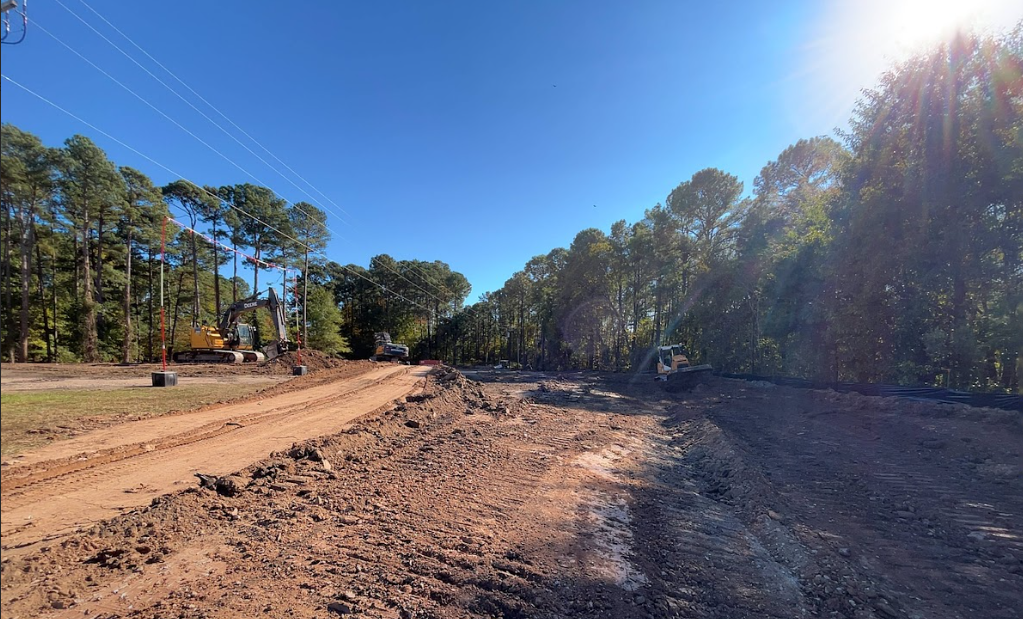 A white tarp covers a narrow walkway next to a building, caution tape across the right.