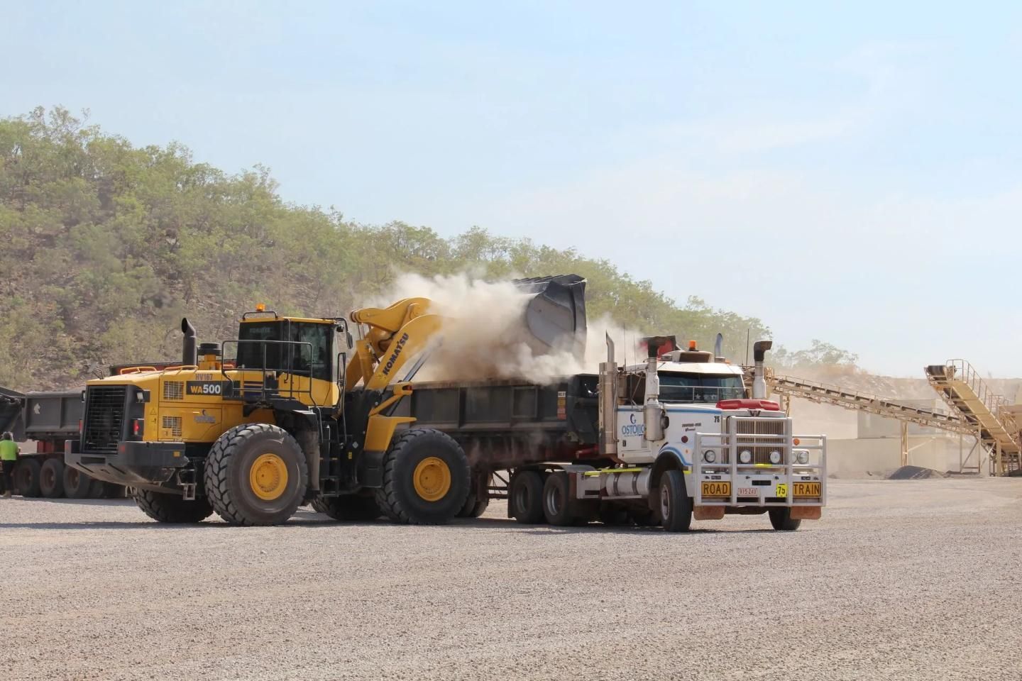 A Yellow Front-end Loader Fills a White Semi-truck's Bed — Ostojic Group in Berrimah, NT