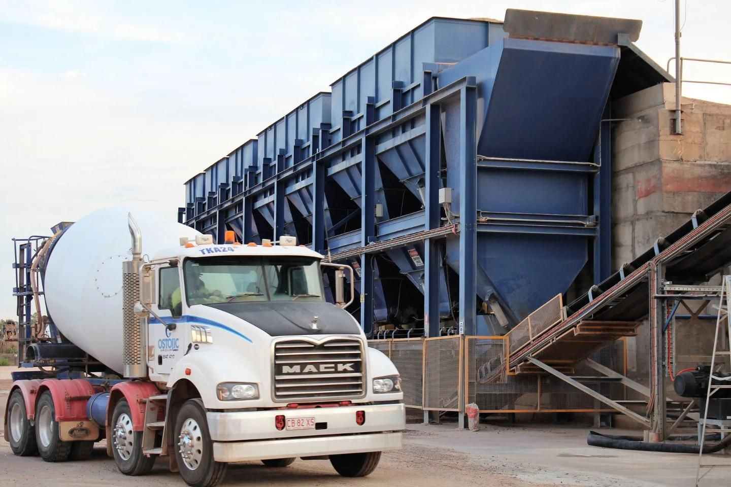 A Concrete Mixer Truck Parked Next to a Blue Concrete Batch Plant — Ostojic Group in Berrimah, NT