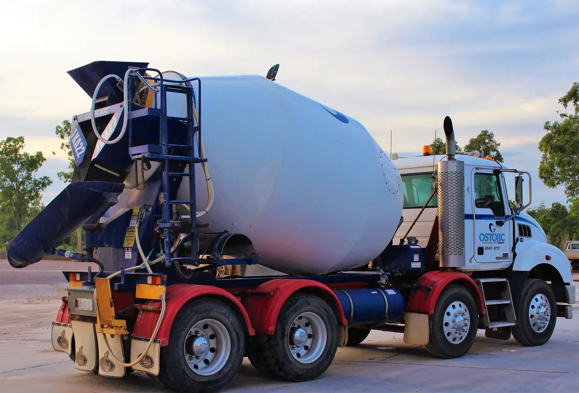 Cement Mixer Truck With White Drum, Parked Outside, Blue And Red Accents