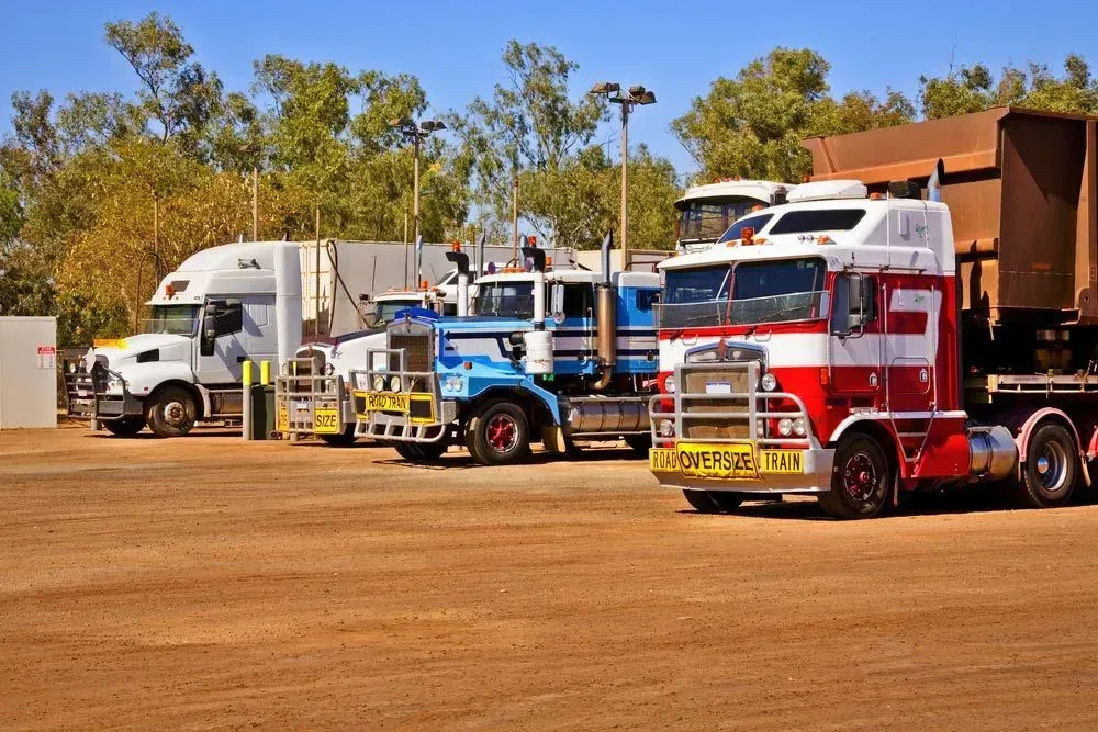Several Semi-trucks Parked in a Dusty Lot Under a Bright Blue Sky — Ostojic Group in Berrimah, NT