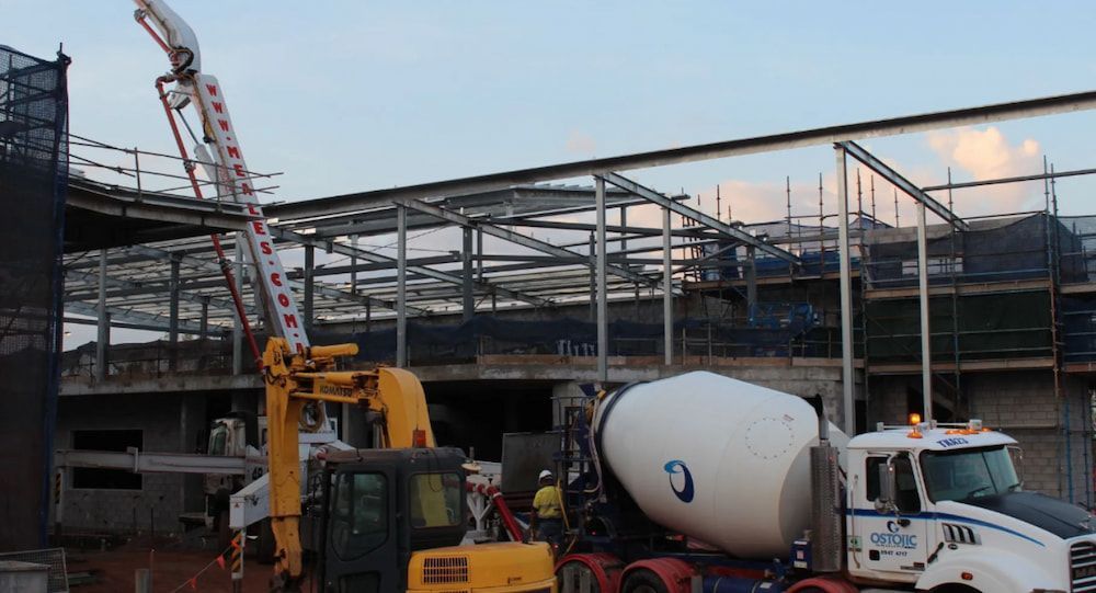 A Concrete Mixer Truck is Being Loaded With Concrete at a Construction Site — Ostojic Group in Berrimah, NT