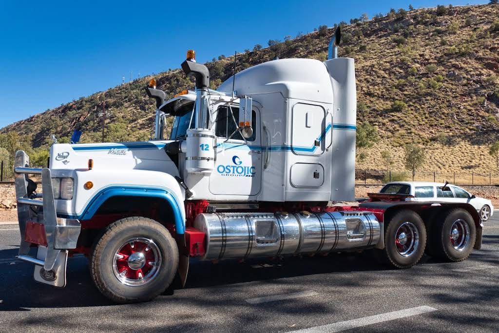 A Semi Truck is Parked on the Side of the Road in Front of a Mountain — Ostojic Group in Berrimah, NT 