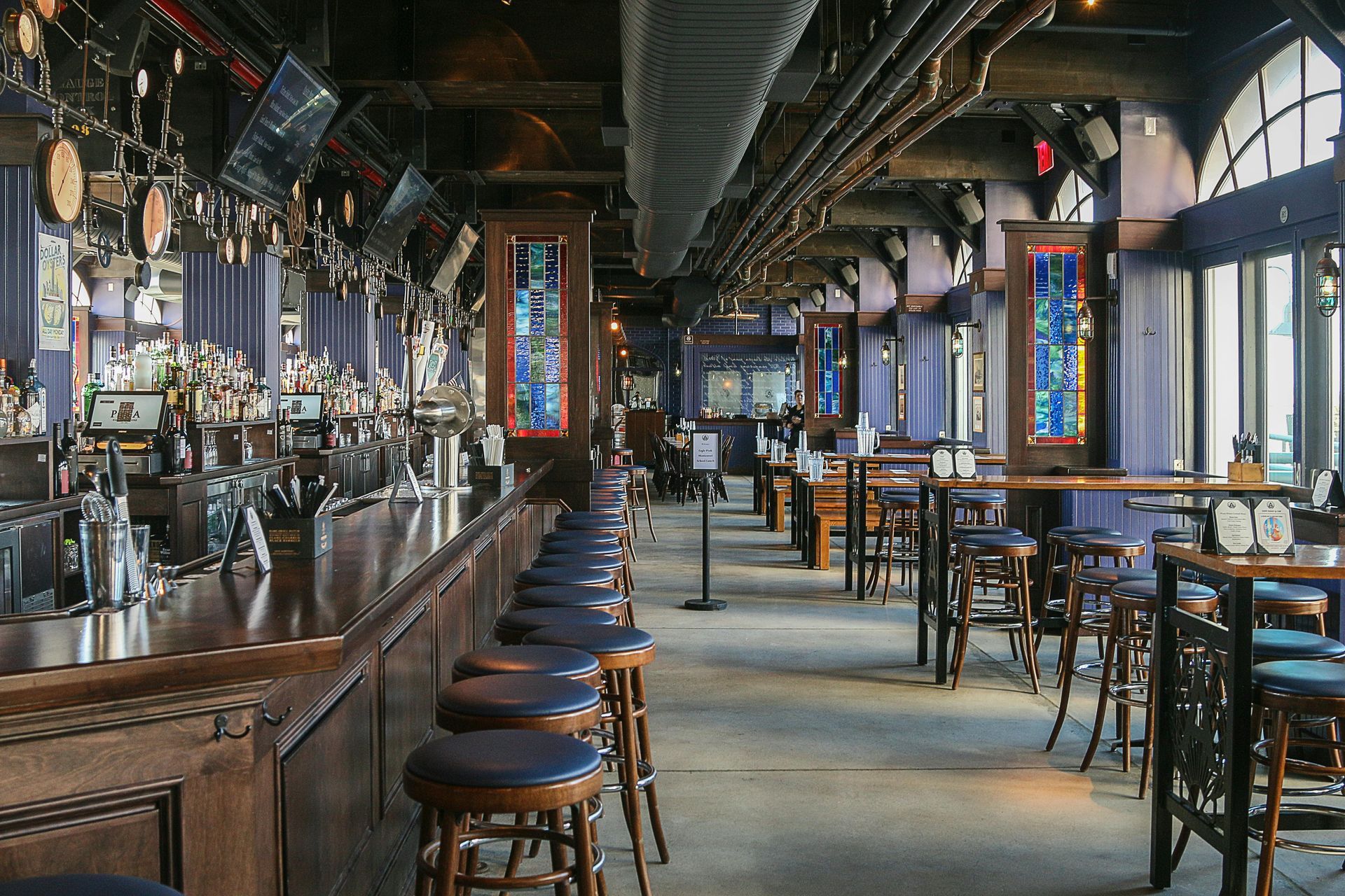 A long row of bar stools are lined up in a restaurant.