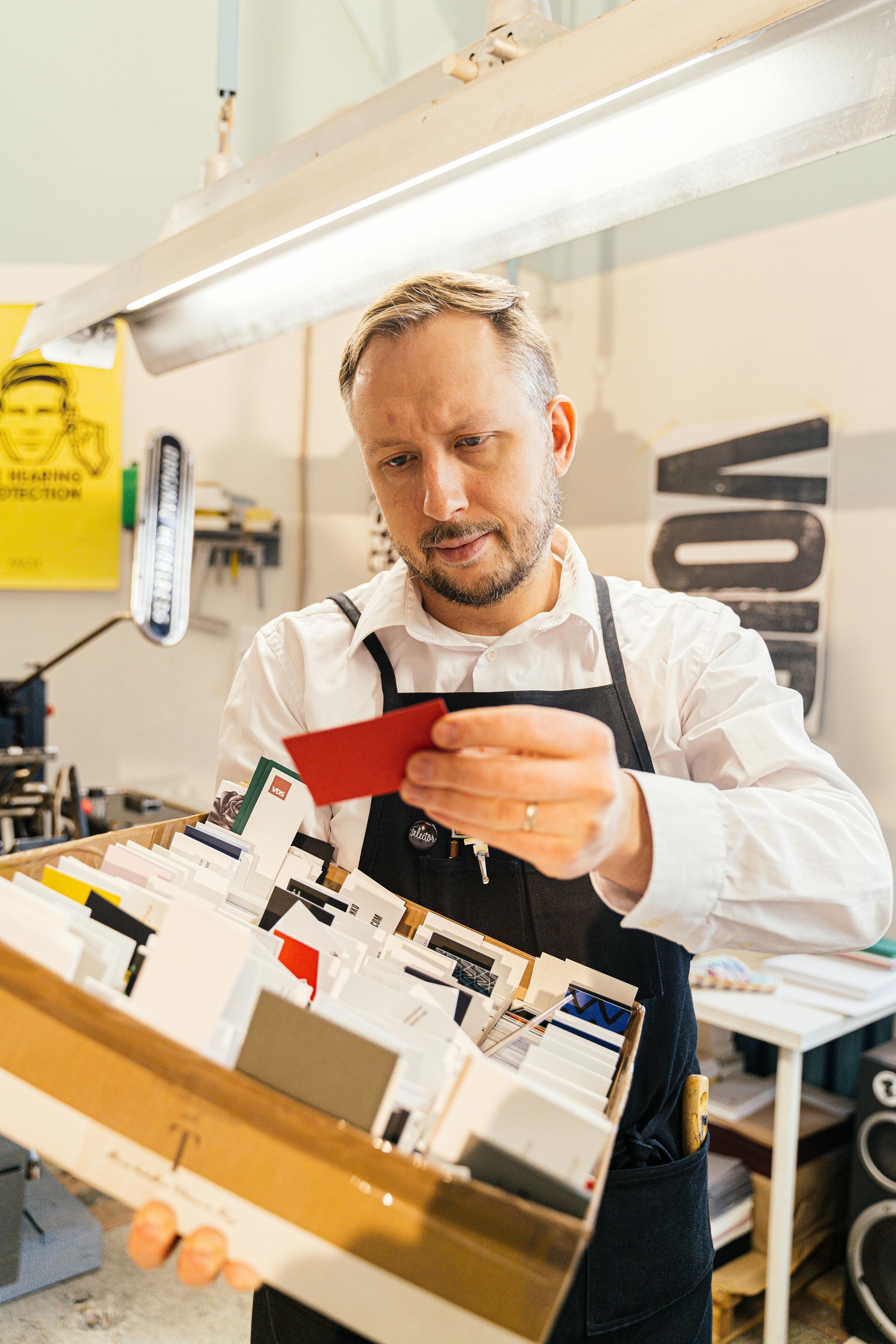 A man and a woman are looking at a piece of paper in an office.