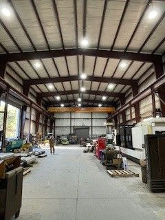 Construction worker in hard hat and vest installs ceiling grid.