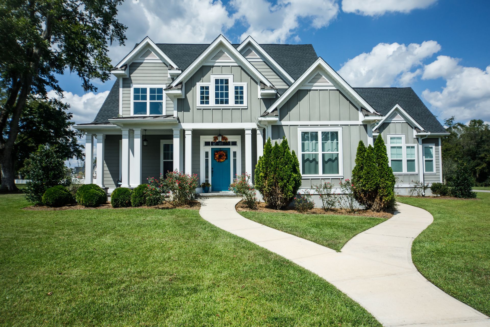 A large house with a blue door and a walkway leading to it.