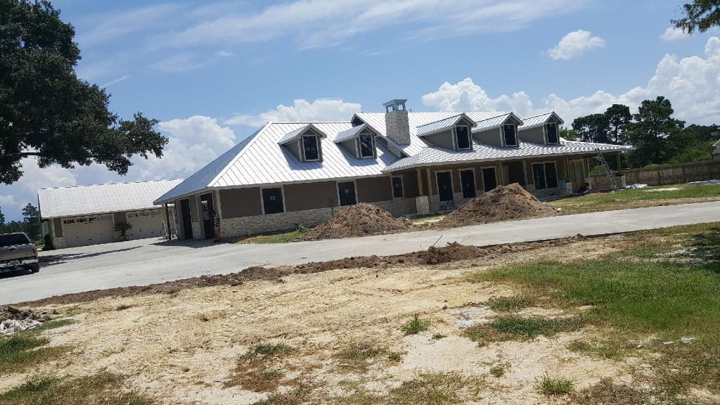A large house with a metal roof is being built.