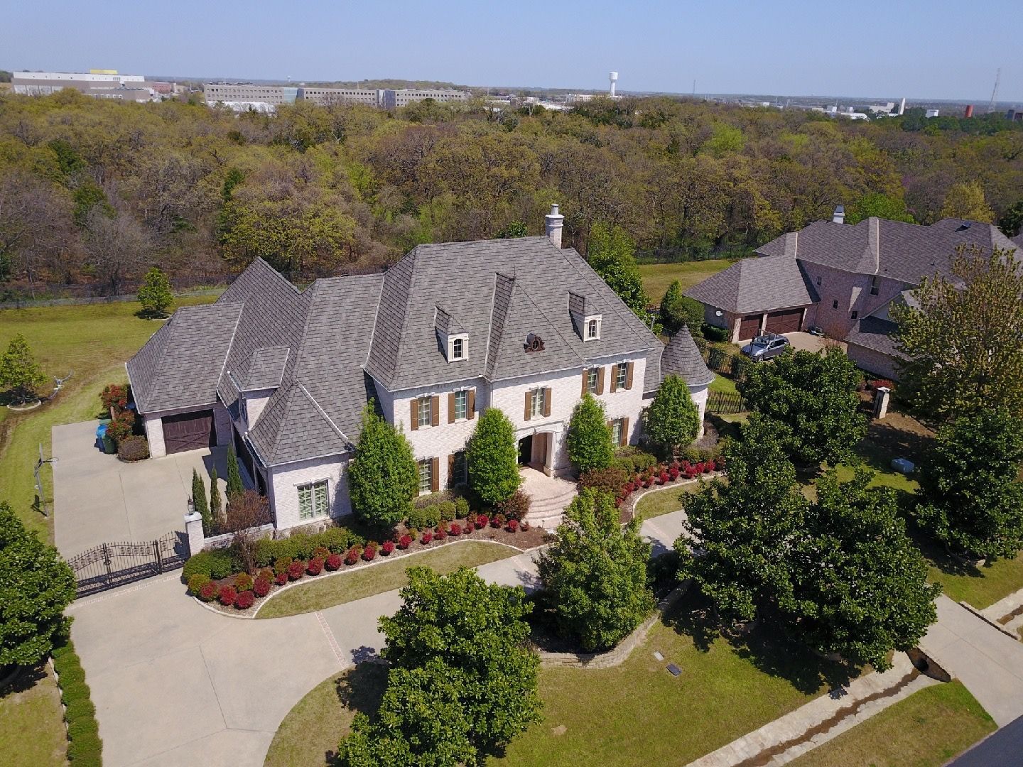 An aerial view of a large house surrounded by trees and grass.