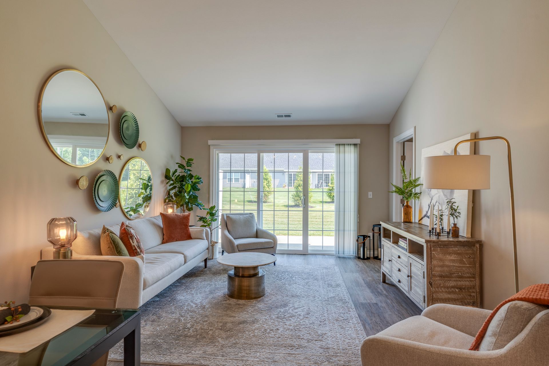 Living room with couch, mirrors, and sliding glass door to yard.