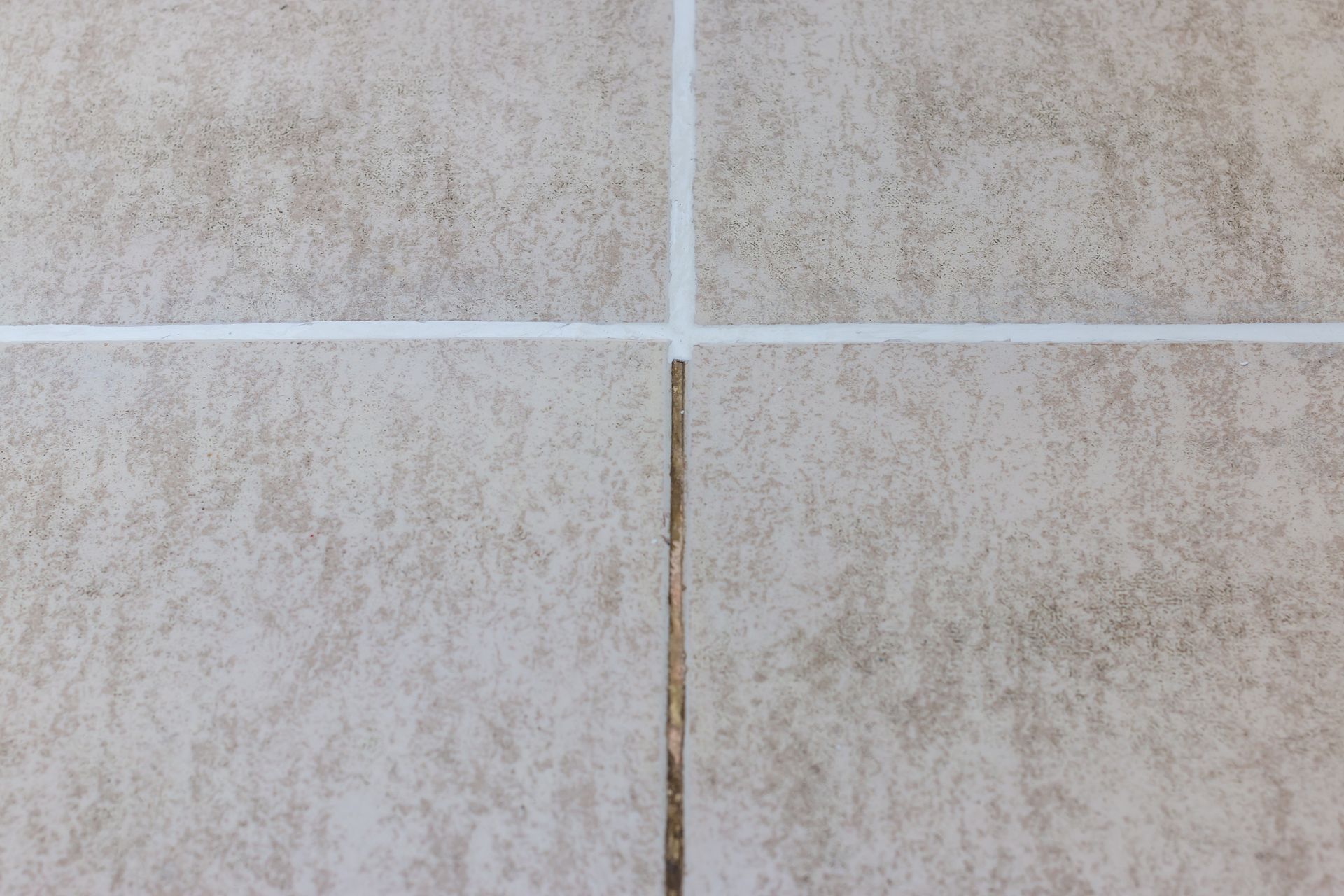 Before and after results of professional grout cleaning on stone floor tiles.