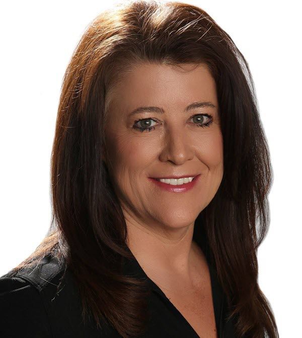 Woman with brown hair smiling, wearing a black top.