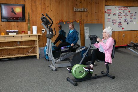 two people are riding exercise bikes in a gym