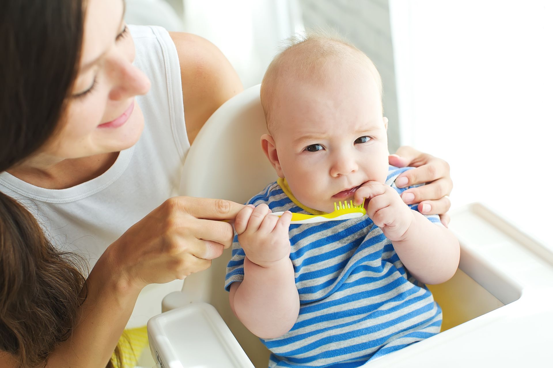Bambino di un anno che impara a prendere confidenza con lo spazzolino dentale
