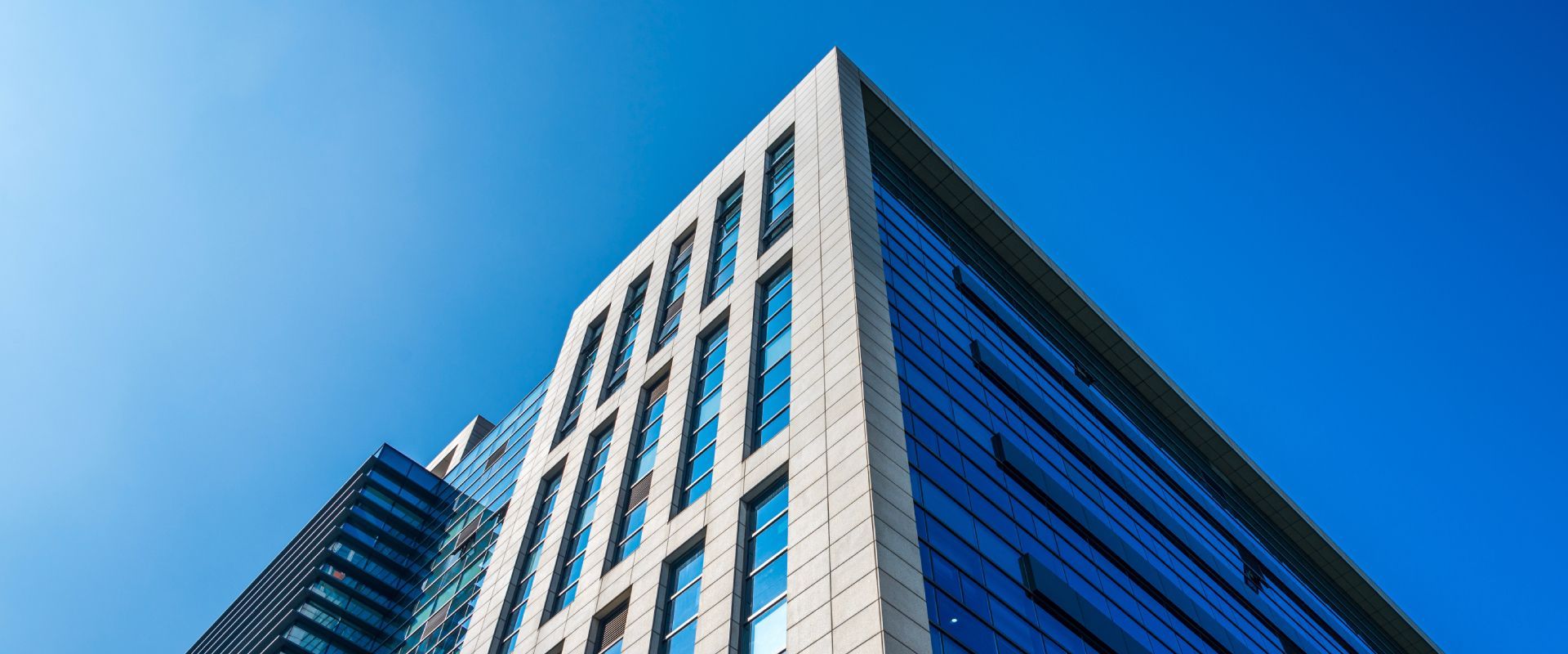 Looking up at a tall building with a blue sky in the background.