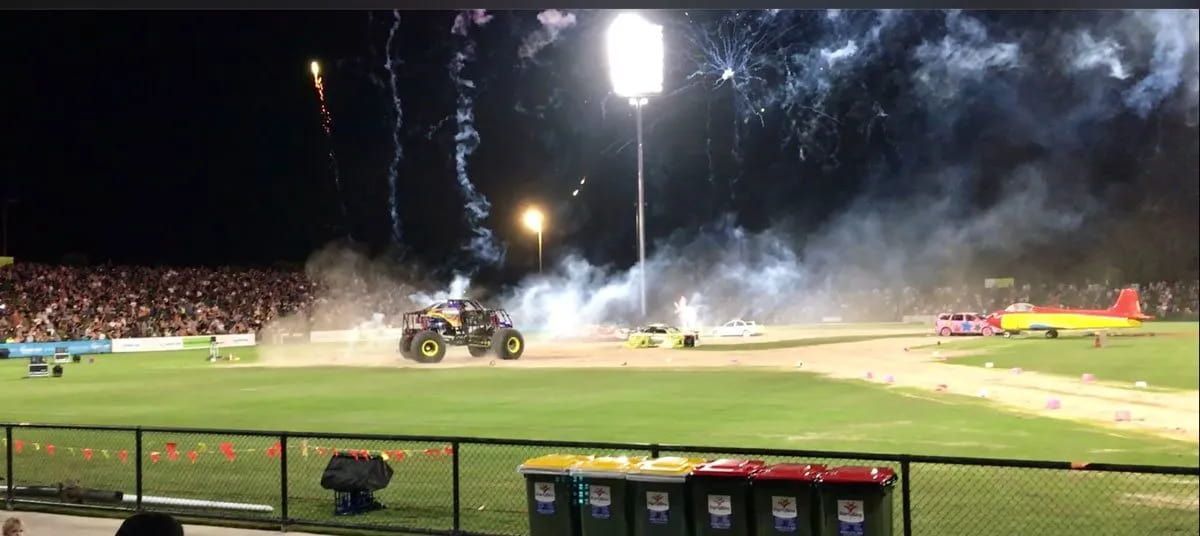 A Monster Truck Is Driving Down A Field With Fireworks In The Background — Party Bins Pty Ltd In Landsborough, QLD