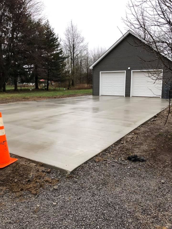 A large house with three garage doors and a concrete driveway