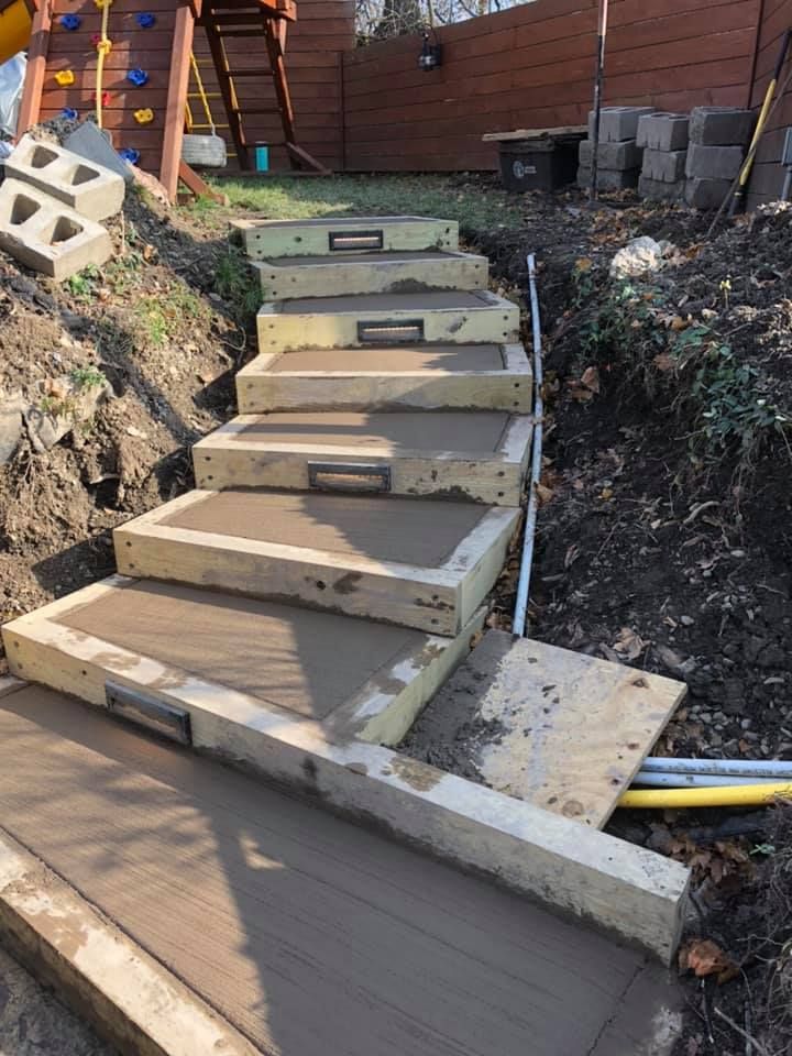 A man is pouring concrete into a wheelbarrow at a construction site.