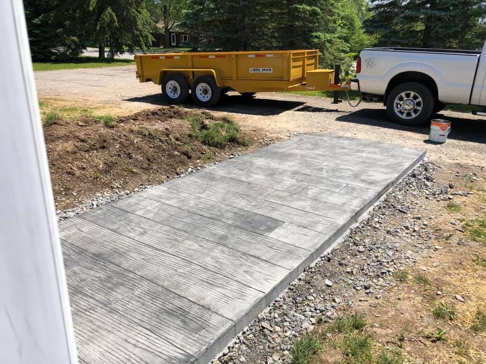 A close up of a concrete walkway being built.