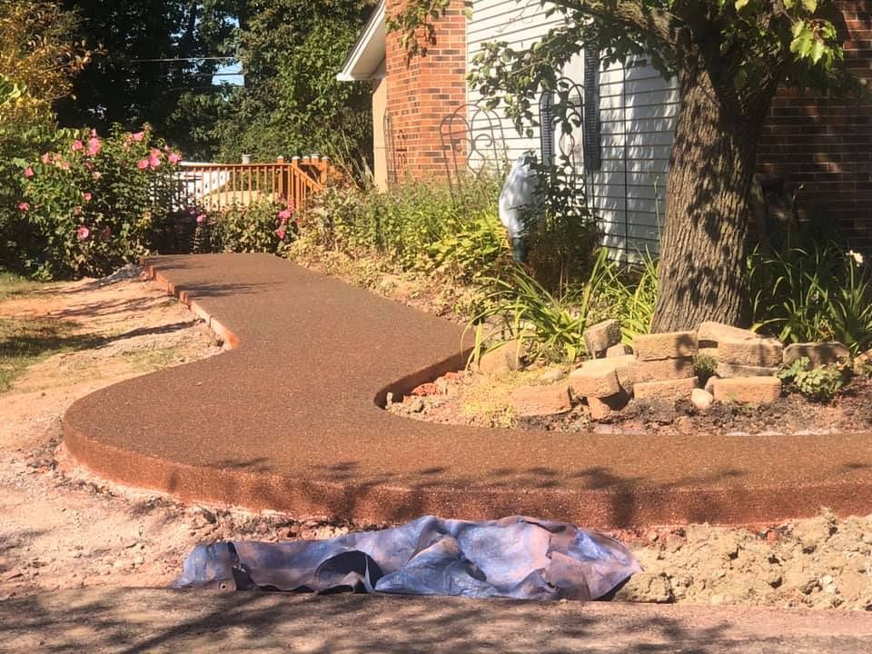 A concrete walkway is being built in front of a house