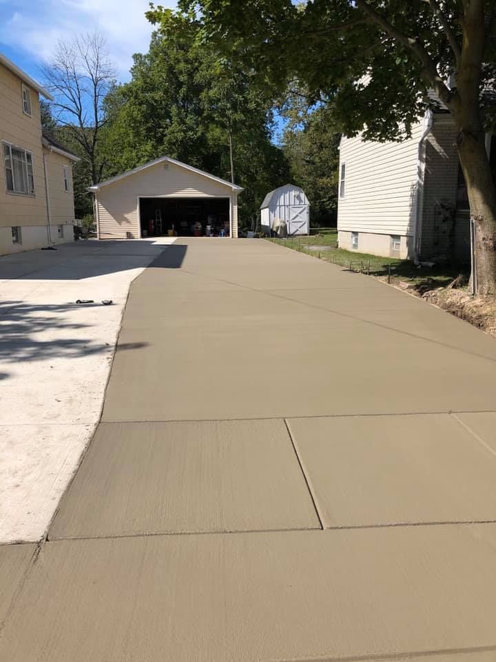 A large white house with two garage doors and a driveway