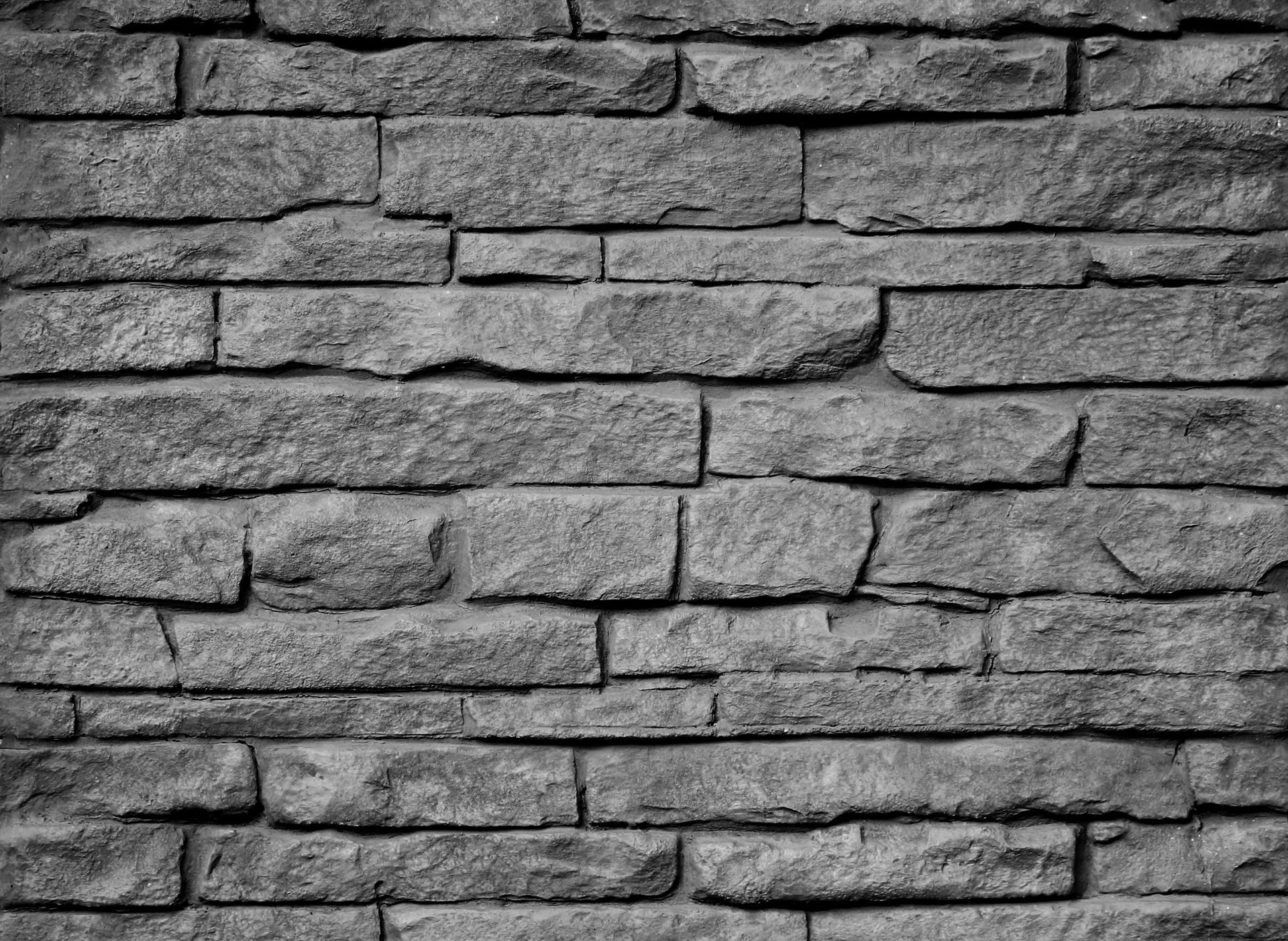 A black and white photo of a brick wall.