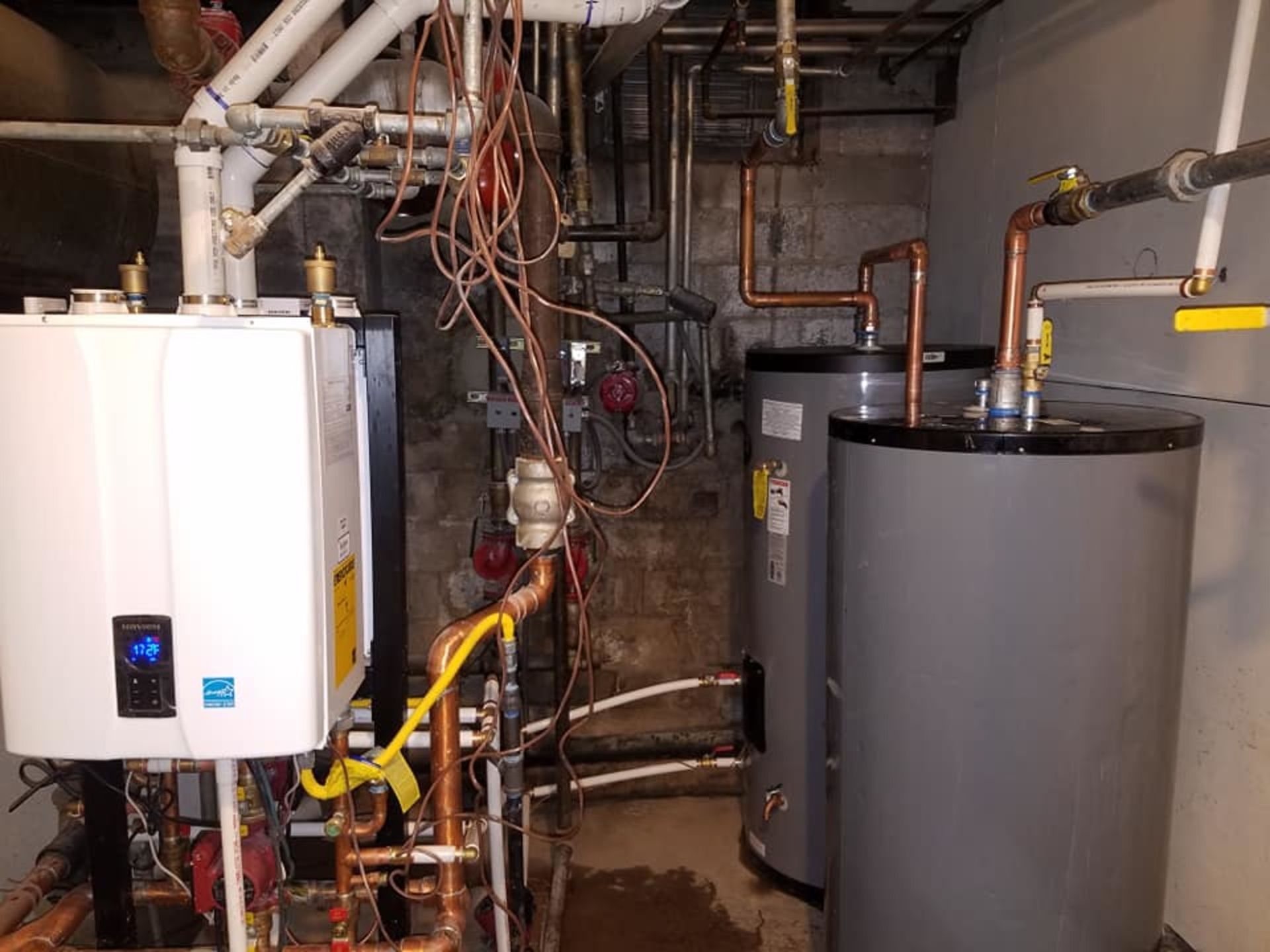 A room with a boiler and a water heater in it.