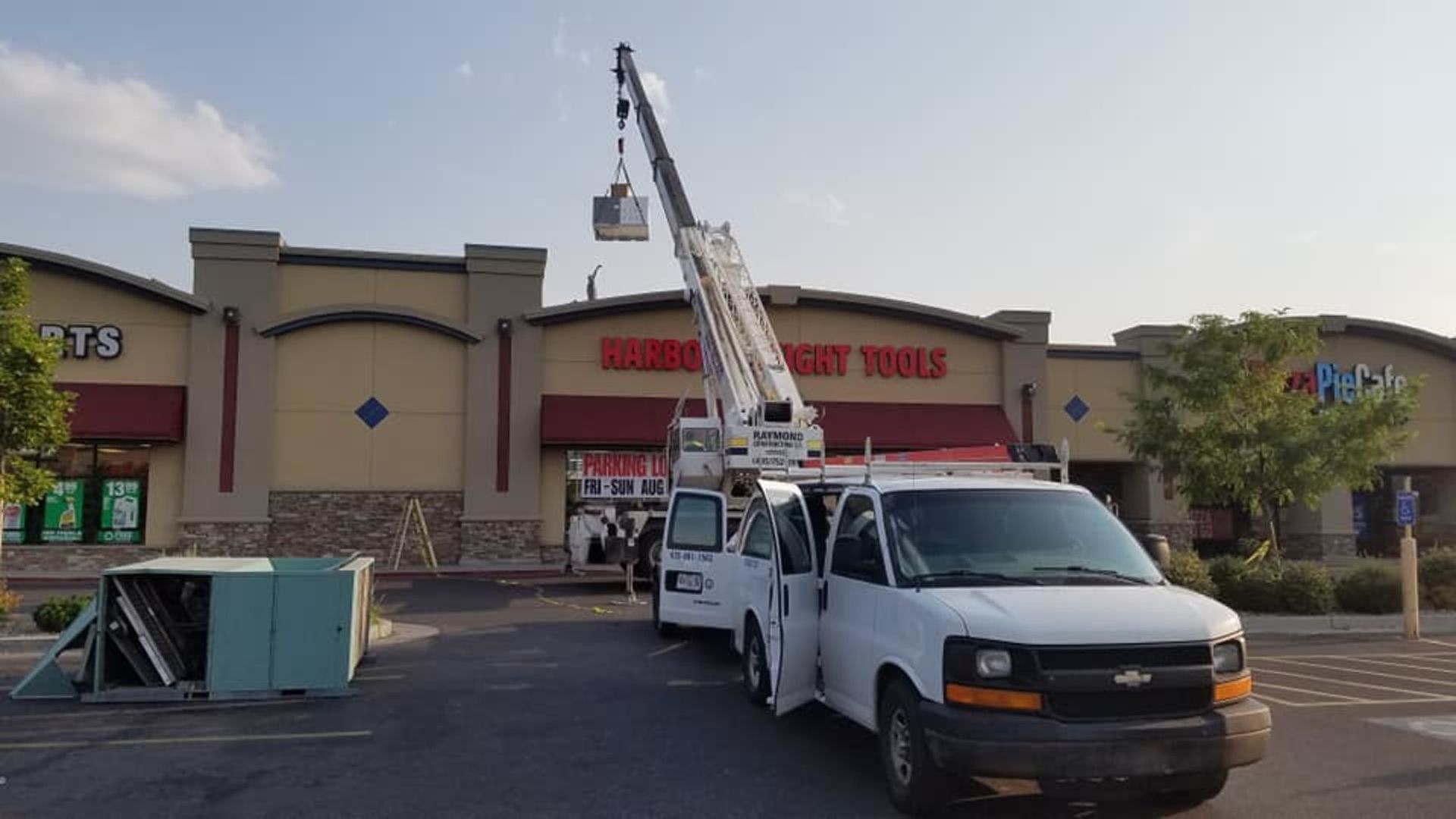 Two white vans are parked in front of a building.