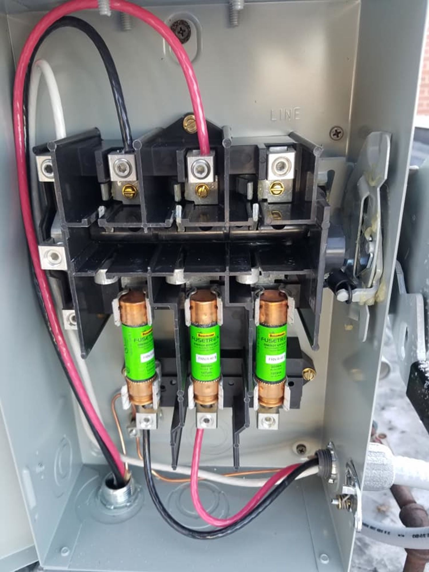 A close up of a electrical box with wires coming out of it.