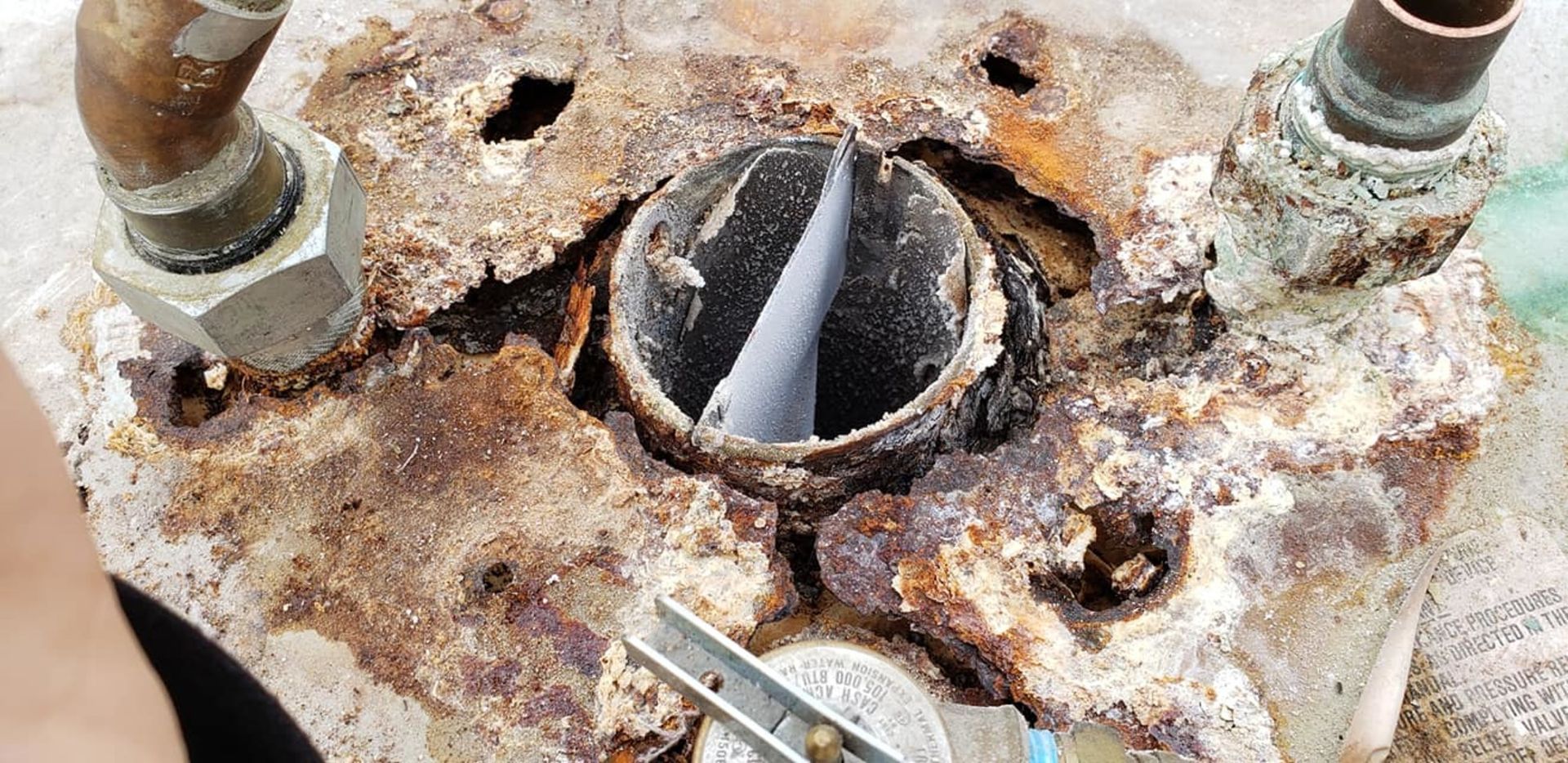 A close up of a rusty piece of metal with a hole in it.