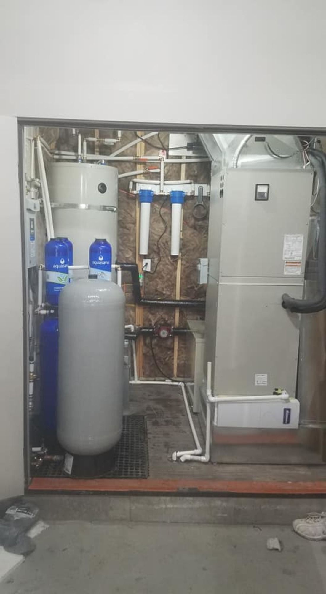 A room with a heater , water heater , and air conditioner.