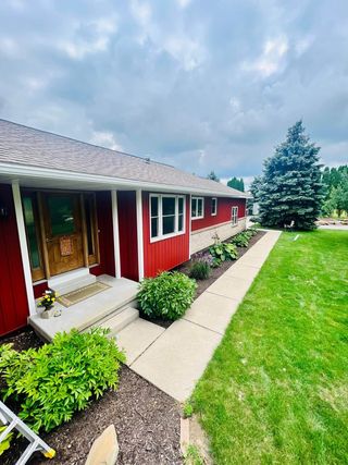 A red house with a walkway leading to the front door.