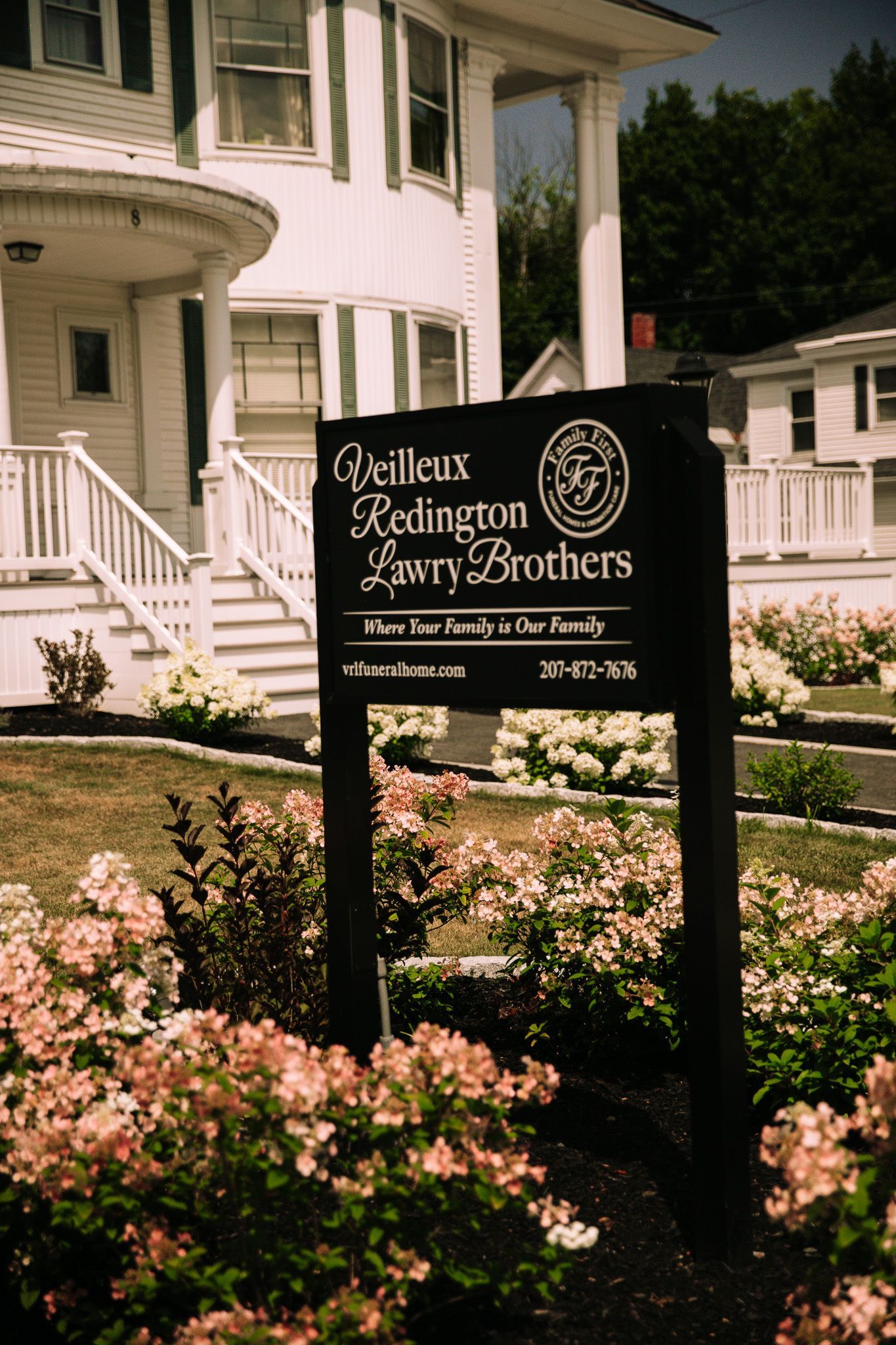 Sign for O'Neill, Reddington, & Fauth, Brothers, a funeral home, in front of white building.