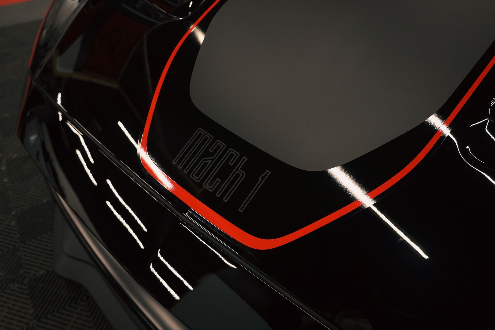 A black dodge charger is parked in a driveway.