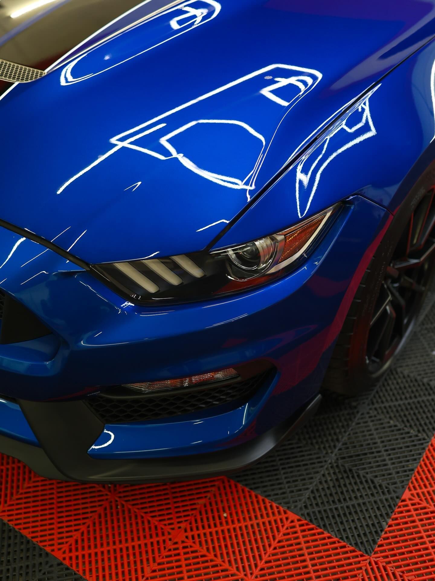 Ceramic-coated Blue Ford Mustang sports car, close-up of front reflections