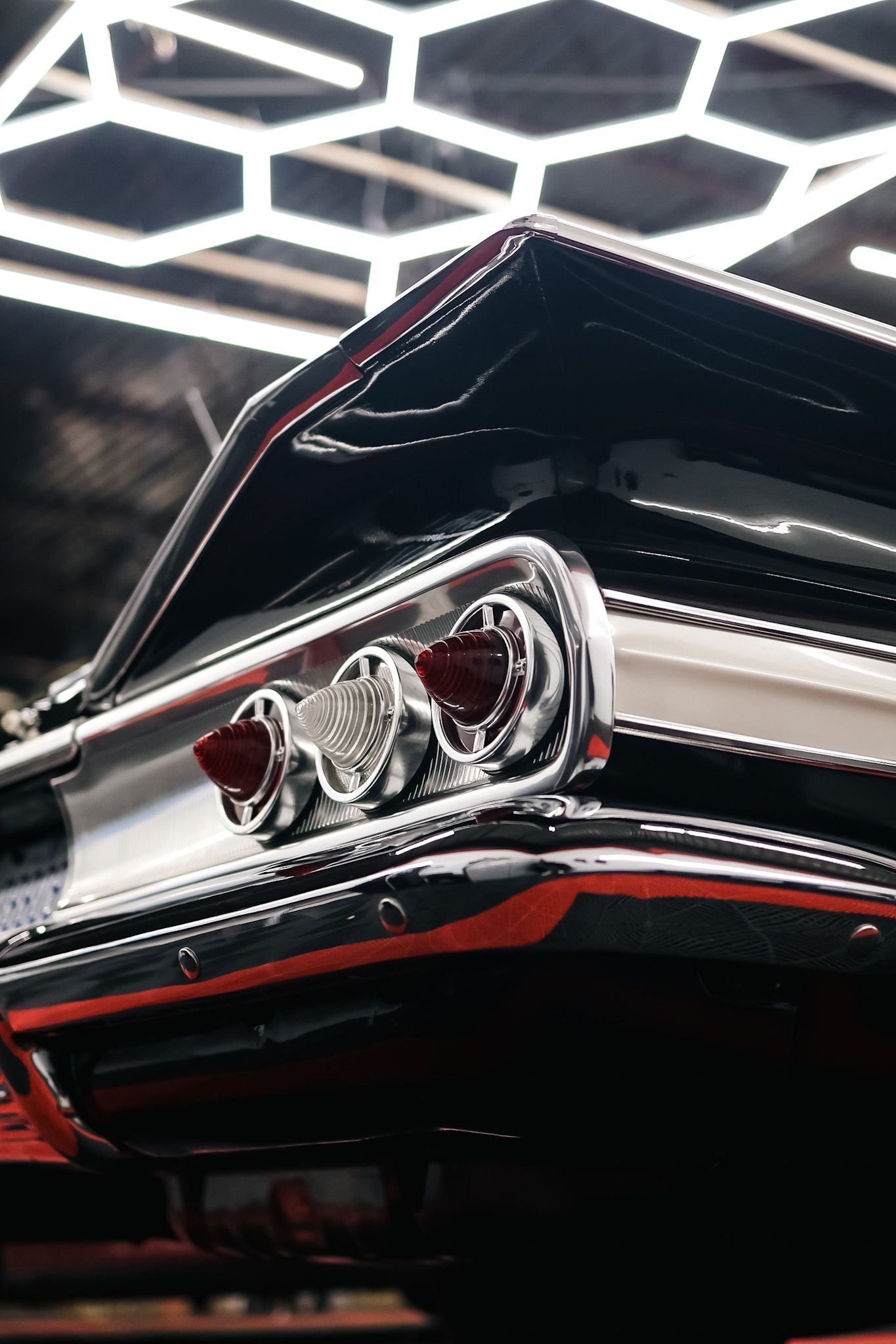 A gray honda civic hatchback is parked in a parking lot.