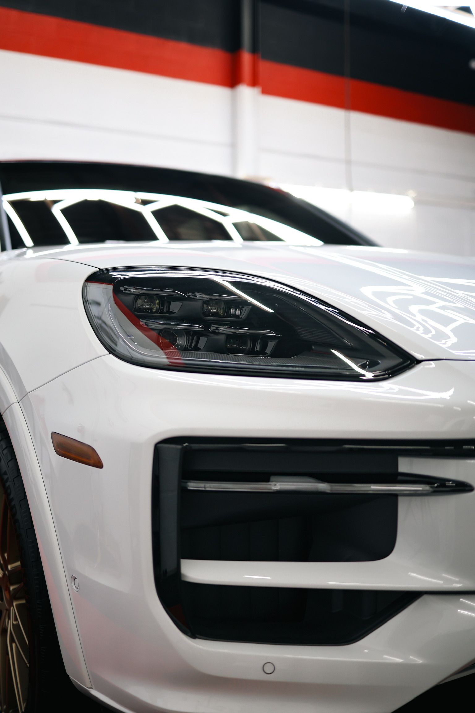 A white porsche macan turbo is parked in a garage.