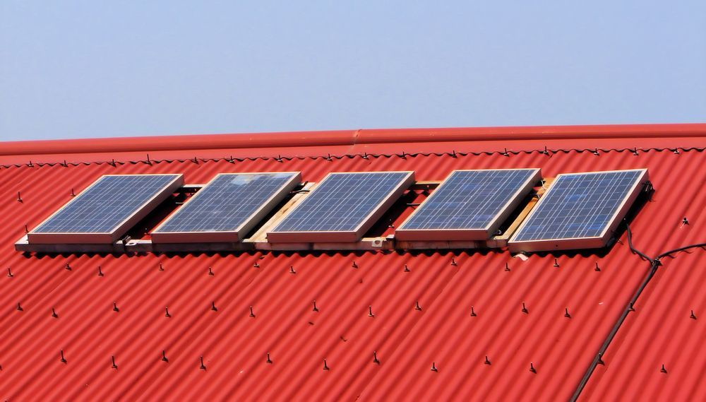 Five Solar Panels Mounted on a Red Corrugated Metal Roof — OzEnergi in Burpengary, QLD