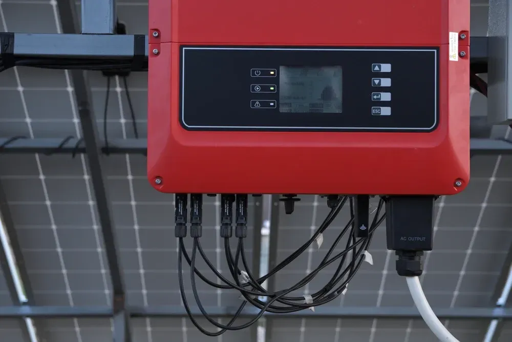 Red solar inverter attached to solar panels; wires connected. — OzEnergi in Beenleigh, QLD