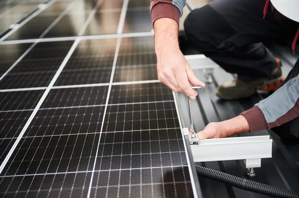 Person installing solar panel on a roof. — OzEnergi in Hope Island, QLD
