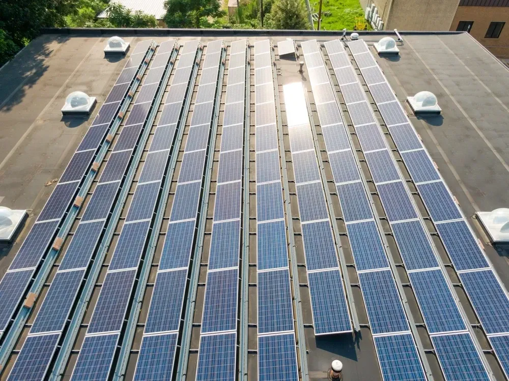 Rooftop covered with rows of solar panels, absorbing sunlight for clean energy. — OzEnergi in Yatala, QLD