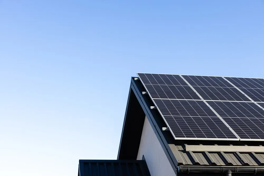 Solar panels on a house roof against a clear, blue sky. — OzEnergi in Robina, QLD