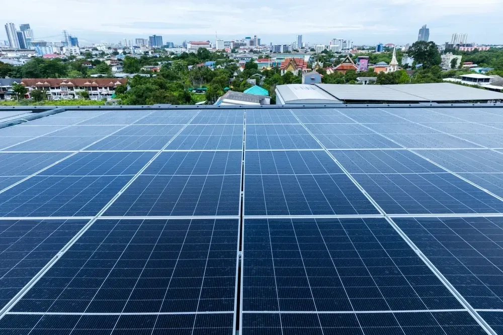 Solar panels on a rooftop with city buildings in the background. — OzEnergi in Pimpama, QLD