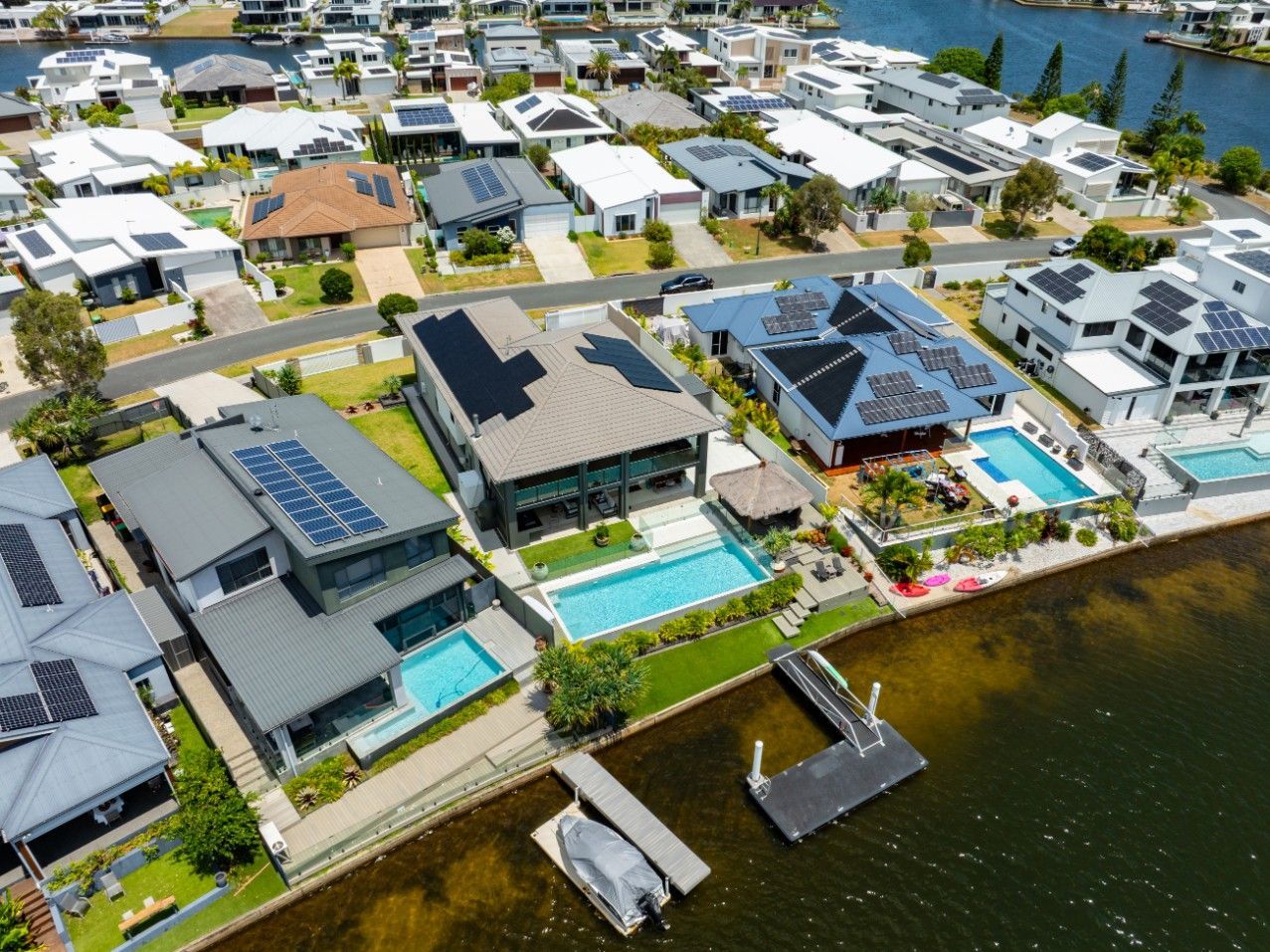 Hands Holding a Miniature Green Earth with A House, Solar Panel, Wind Turbines — OzEnergi in Caloundra West, QLD